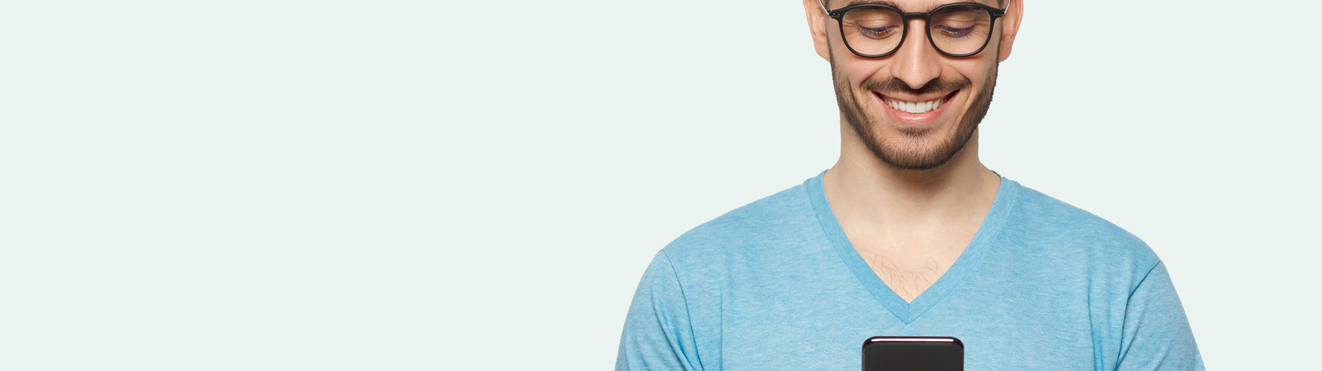 Smilende mand som kigger på sin smartphone