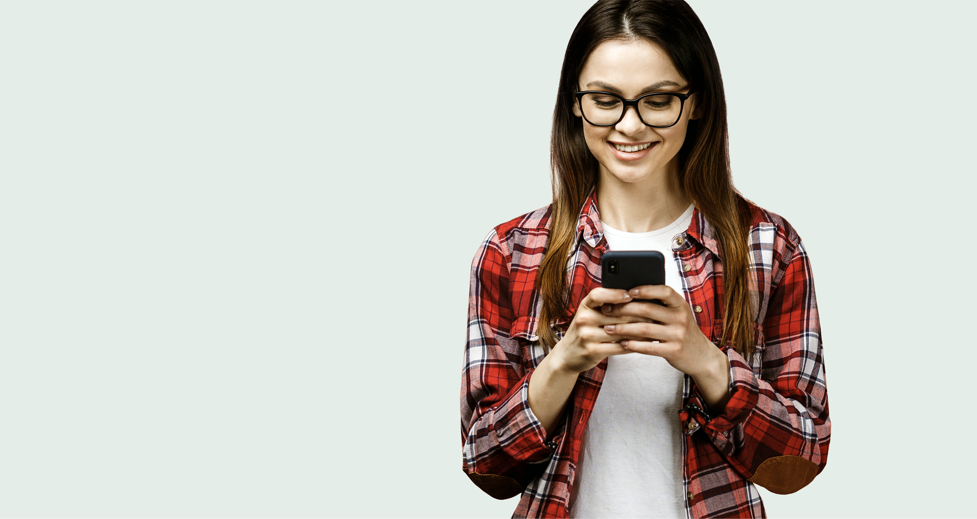 Smilende kvinde kigger på smartphone